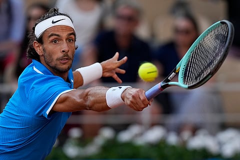 Lorenzo Musetti returns a shot to Novak Djokovic